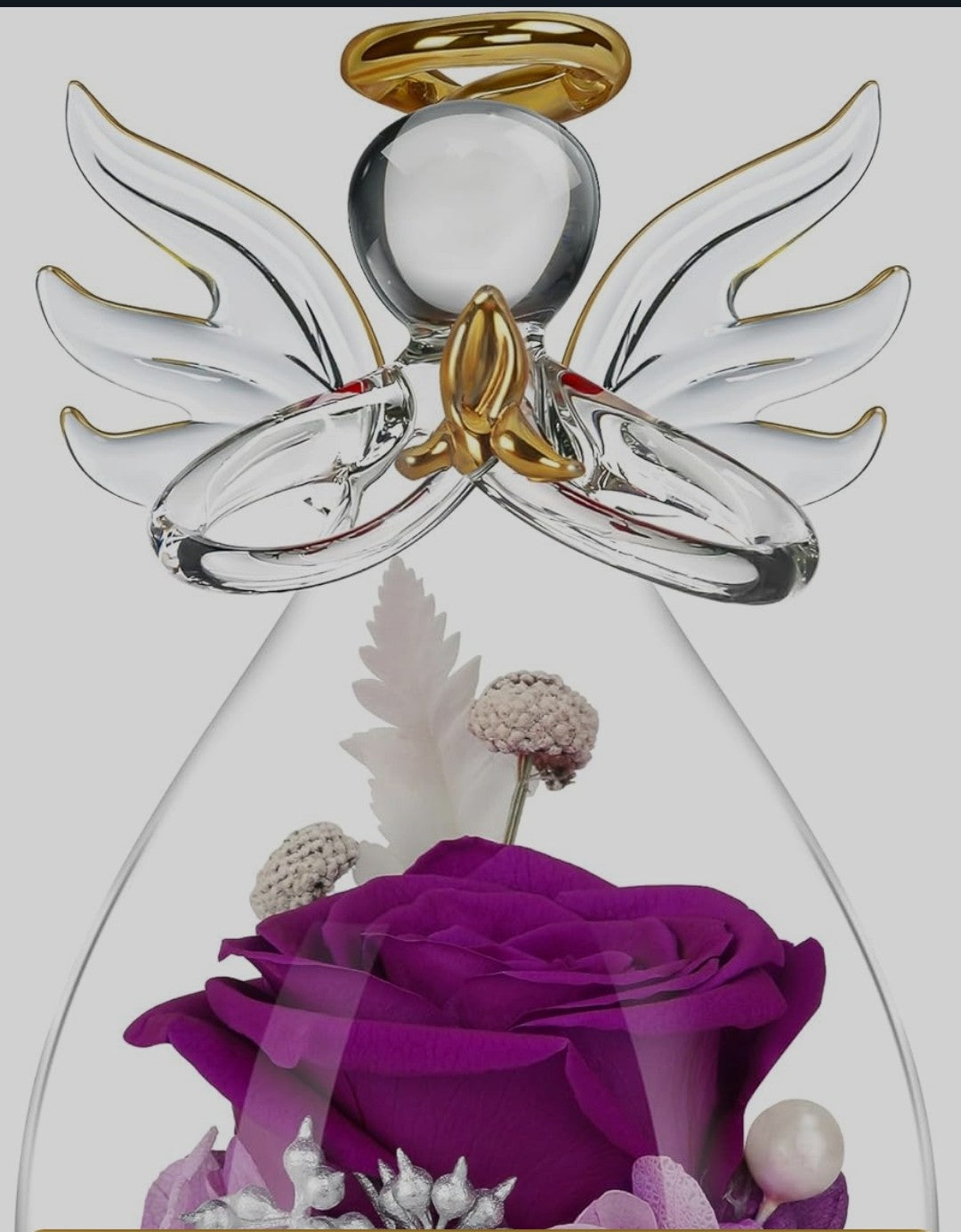 Purple rose preserved in an angel glass figurine